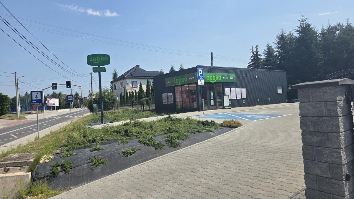 Widok pawilonu od strony ulicy z zabudową mieszkaniową w tle